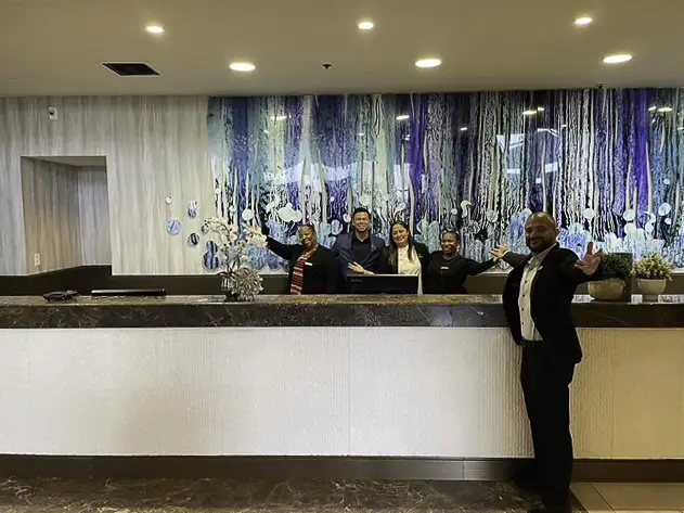 A reception area with four people, one standing apart.