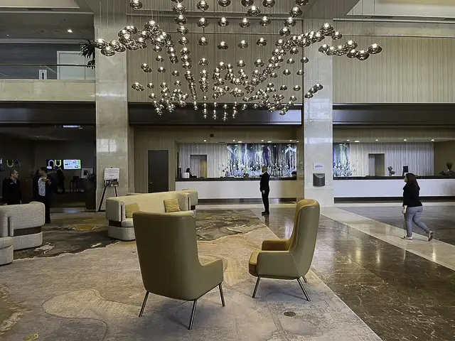 Modern lobby with stylish chairs and a decorative ceiling installation.