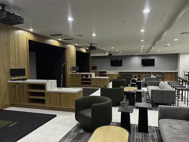 Modern office lounge area with seating and desks.