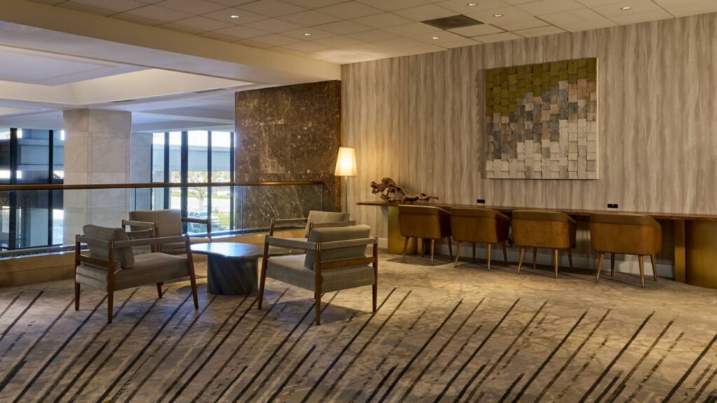 A cozy lounge area with chairs, tables, and warm lighting.